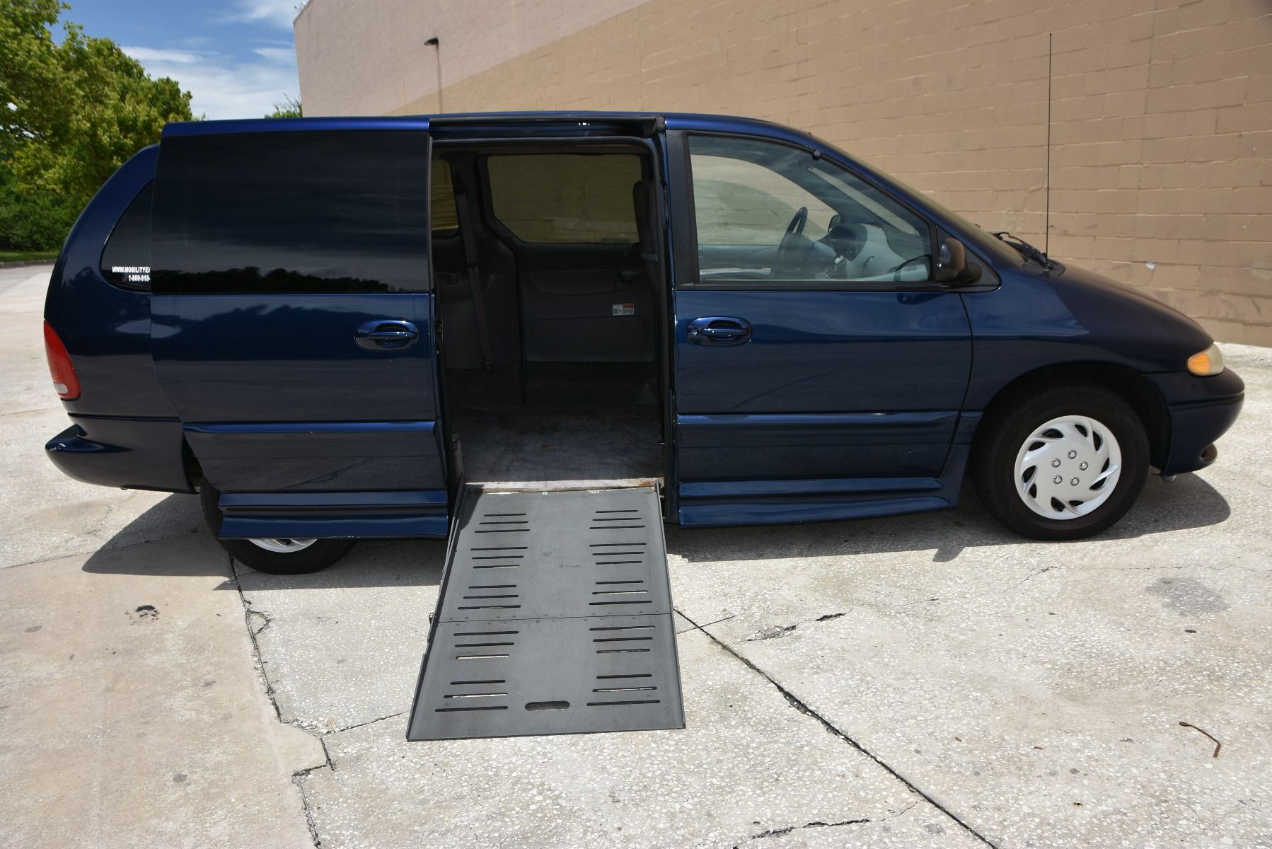 Passenger Side of a Blue Dodge Grand Caravan Wheelchair Van with ramp deployed