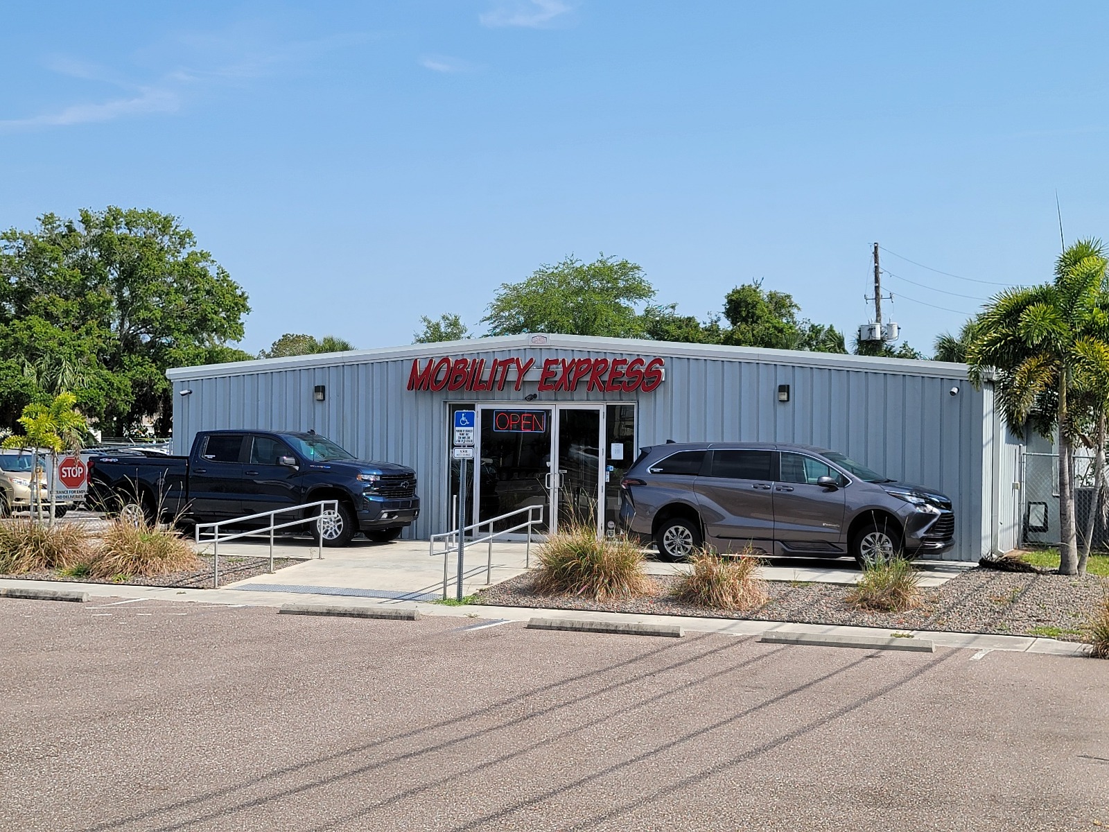 Mobility Express Largo Store A building with the words "Mobility Express" on the front in red. There are two handicap accessible vehicles parked in front of the building, a blue truck and a gray minivan.