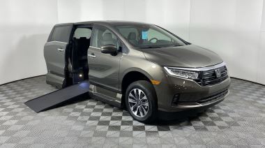 A gray Honda Odyssey with AMS wheelchair van side entry conversion with ramp deployed from open rear hatch.