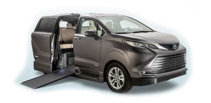 A gray Toyota Sienna Hybrid wheelchair van with VMI Northstar conversion, with the ramp deployed from the passenger sliding doorway.