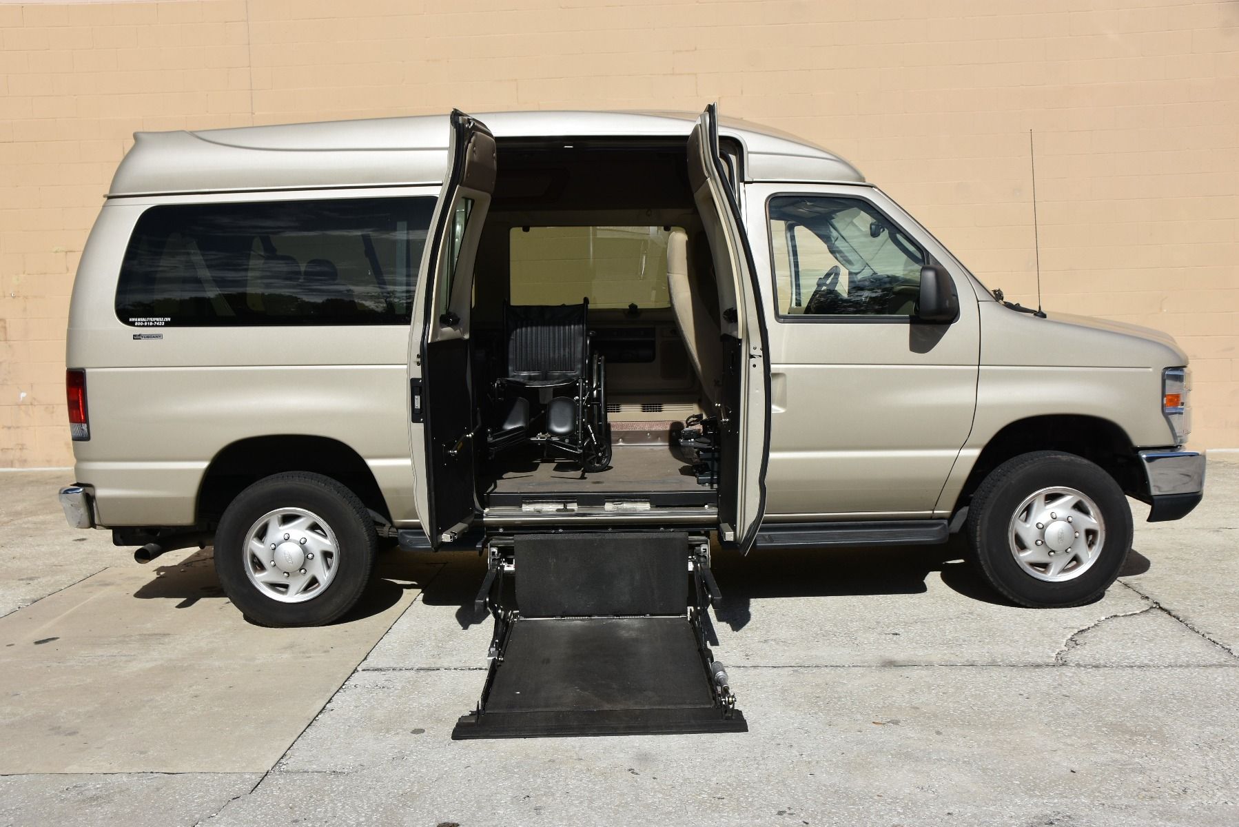 Passenger Side of a Gold 2013 Ford E-350 Full Size Wheelchair Van with Lift Deployed from the middle doors.