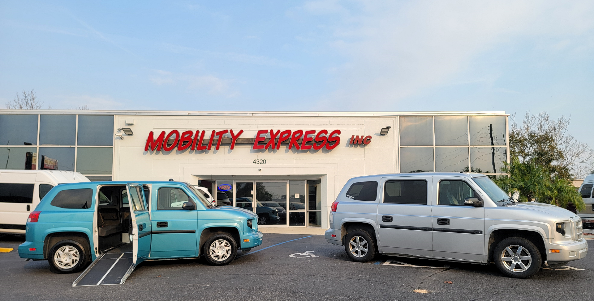 Silver Ford Explorer wheelchair accessible SUV with the ramp deployed from the open passenger side rear door.